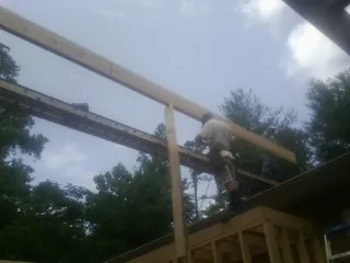 Carpenter setting a ridge beam over a new addition frame — Ice Dam Removal by Roofing Brothers in Mazomanie