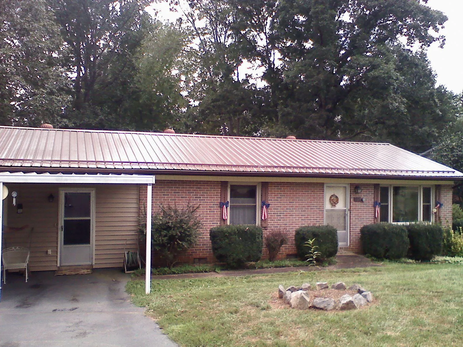 Bronze metal roof and carport on a brick ranch home — Roof Repair work by our crew in Mazomanie