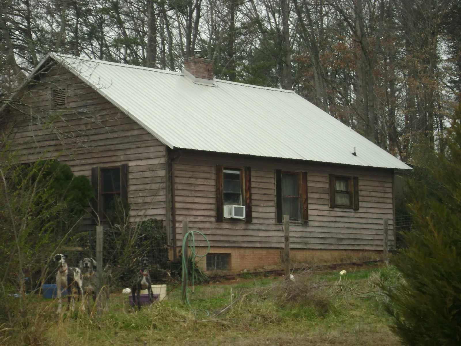 White metal roof on an old wood sided farmhouse, from a Metal Roof Installation job in Mazomanie